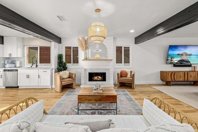 3167 Camarillo Ave, Oceanside, CA 92056 - living area with light wood finished floors, beamed ceiling, a fireplace, and recessed lighting