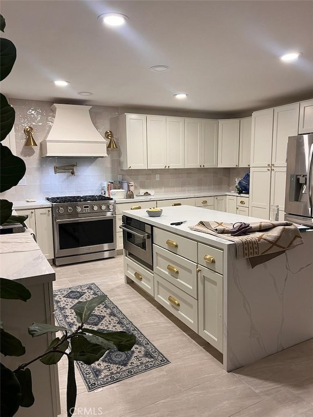35658 Denali Way, Winchester, CA 92596 - kitchen featuring stainless steel appliances, premium range hood, backsplash, light stone countertops, and white cabinetry