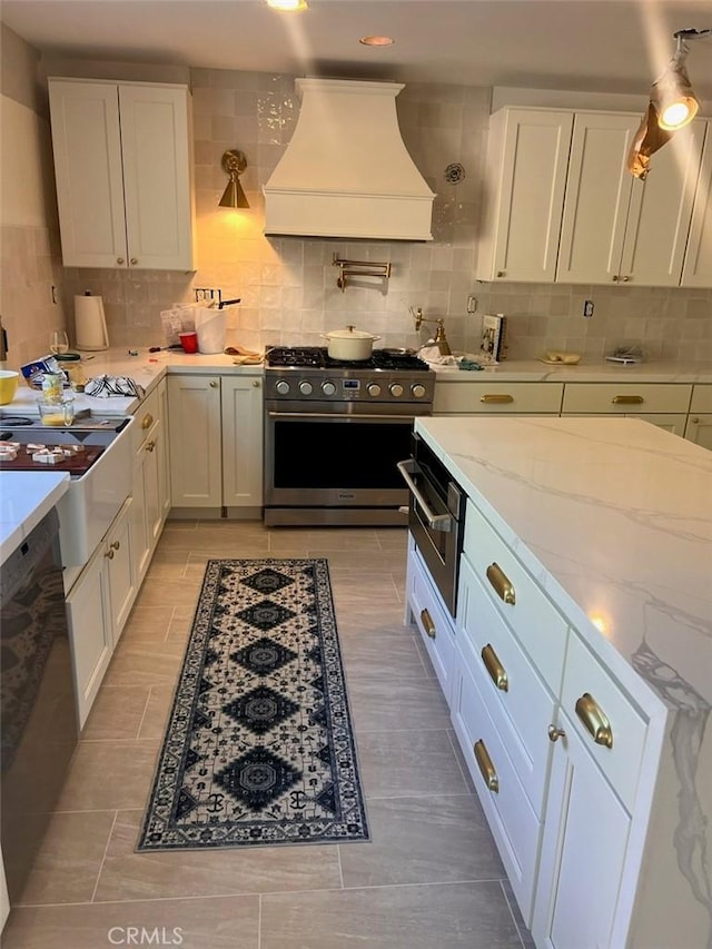 35658 Denali Way, Winchester, CA 92596 - kitchen featuring premium range hood, high end stainless steel range, a warming drawer, white cabinets, and tasteful backsplash