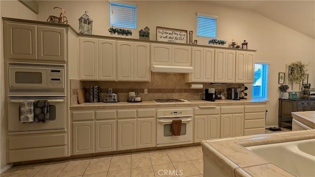 3242 Ashbury Ave, Madera, CA 93637 - kitchen with white appliances, tile counters, light tile patterned flooring, and high vaulted ceiling