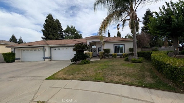 3242 Ashbury Ave, Madera, CA 93637 - mediterranean / spanish house with stucco siding, concrete driveway, a tiled roof, and a garage