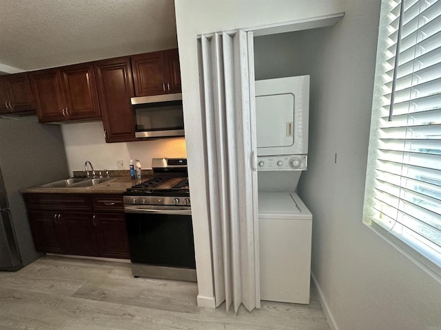 550206 E University Ave, San Diego, CA 92105 - laundry area featuring stacked washer / drying machine and light wood finished floors
