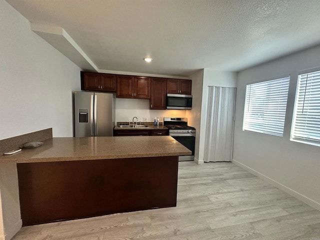 550206 E University Ave, San Diego, CA 92105 - kitchen with appliances with stainless steel finishes, a peninsula, light wood-type flooring, and dark brown cabinets