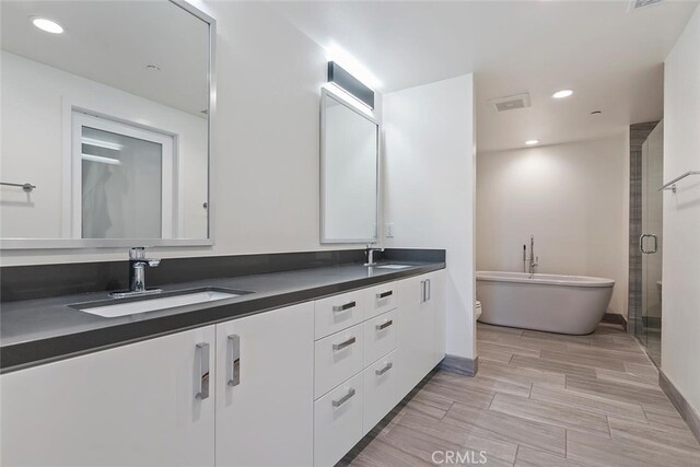 4240 Laurel Canyon Blvd Unit 307, Studio City, CA 91604 - full bath featuring double vanity, a soaking tub, a shower stall, recessed lighting, and wood finish floors