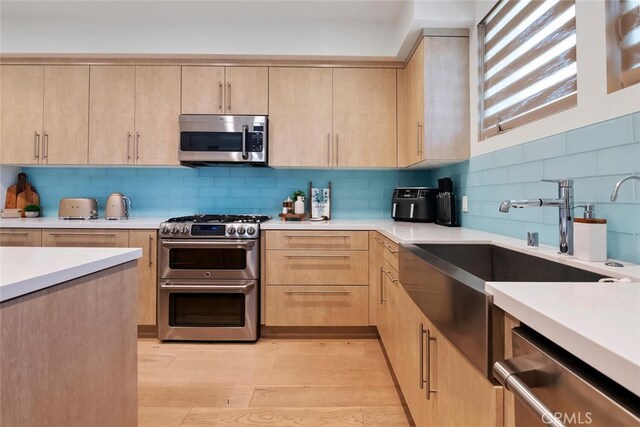 4240 Laurel Canyon Blvd Unit 307, Studio City, CA 91604 - kitchen with stainless steel appliances, light brown cabinetry, light countertops, tasteful backsplash, and light wood-style floors
