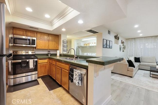 5885 El Cajon Blvd Unit 105, San Diego, CA 92115 - kitchen featuring appliances with stainless steel finishes, open floor plan, ornamental molding, a peninsula, and a raised ceiling