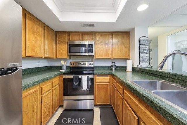 5885 El Cajon Blvd Unit 105, San Diego, CA 92115 - kitchen featuring stainless steel appliances, a raised ceiling, ornamental molding, dark countertops, and recessed lighting