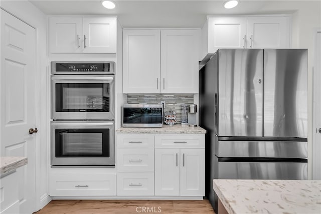 13982 Claremont Ln, Rancho Cucamonga, CA 91739 - kitchen featuring stainless steel appliances, white cabinets, light stone counters, light wood-style flooring, and recessed lighting