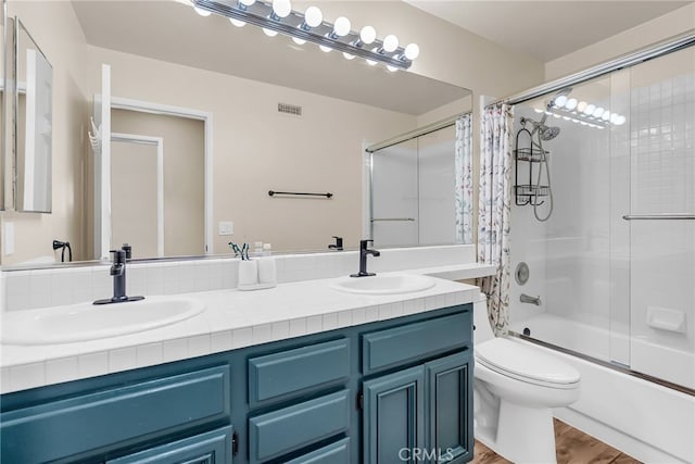 13982 Claremont Ln, Rancho Cucamonga, CA 91739 - full bathroom featuring double vanity, shower / bath combination with glass door, and wood finished floors