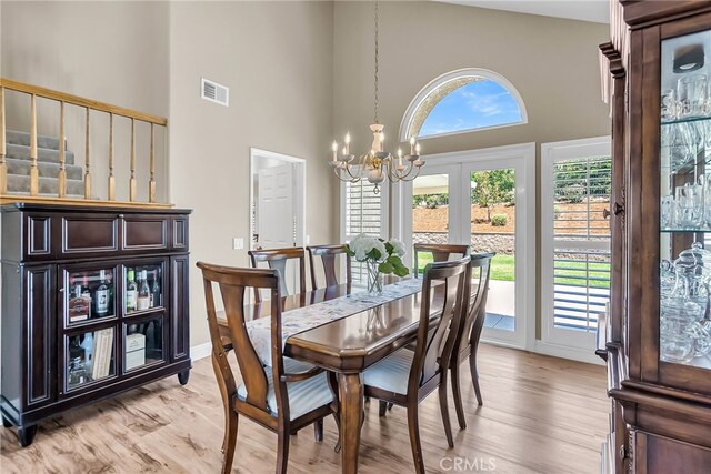 13982 Claremont Ln, Rancho Cucamonga, CA 91739 - dining space featuring a chandelier, a towering ceiling, and light wood finished floors