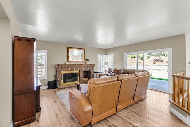 13982 Claremont Ln, Rancho Cucamonga, CA 91739 - living room featuring light wood-type flooring, a brick fireplace, and healthy amount of natural light