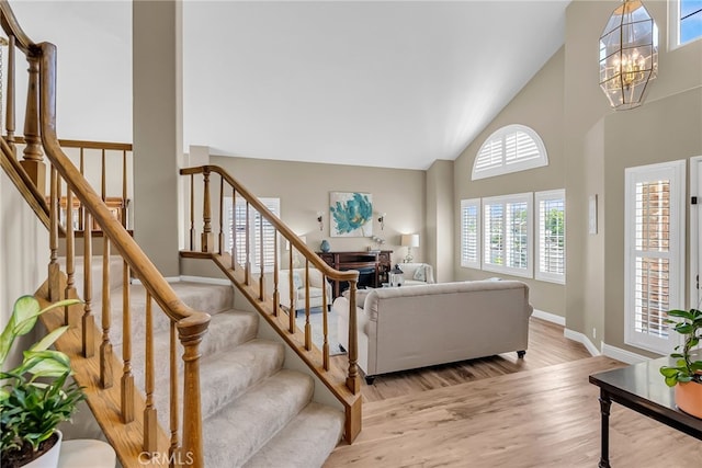 13982 Claremont Ln, Rancho Cucamonga, CA 91739 - living room with high vaulted ceiling, a chandelier, stairway, and light wood-type flooring