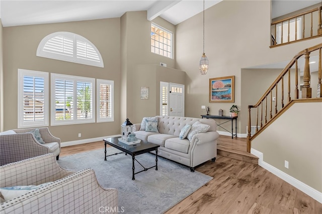 13982 Claremont Ln, Rancho Cucamonga, CA 91739 - living area featuring wood finished floors, high vaulted ceiling, healthy amount of natural light, stairway, and beam ceiling