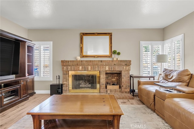 13982 Claremont Ln, Rancho Cucamonga, CA 91739 - living room featuring light wood finished floors, a fireplace, and healthy amount of natural light