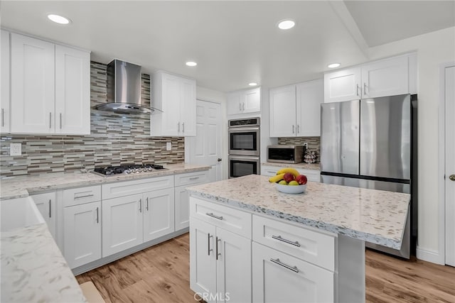 13982 Claremont Ln, Rancho Cucamonga, CA 91739 - kitchen with wall chimney exhaust hood, appliances with stainless steel finishes, light wood-type flooring, white cabinets, and tasteful backsplash
