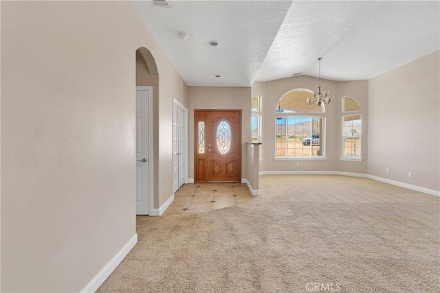 15090 Olema Rd, Apple Valley, CA 92307 - foyer featuring light colored carpet, arched walkways, a chandelier, vaulted ceiling, and a textured ceiling