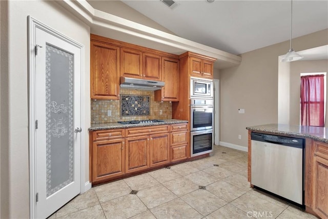 15090 Olema Rd, Apple Valley, CA 92307 - kitchen featuring appliances with stainless steel finishes, under cabinet range hood, brown cabinetry, backsplash, and stone countertops