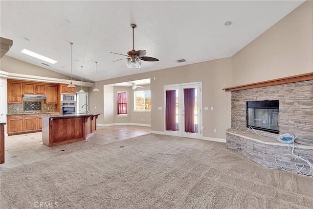 15090 Olema Rd, Apple Valley, CA 92307 - kitchen featuring open floor plan, appliances with stainless steel finishes, vaulted ceiling, brown cabinets, and a ceiling fan