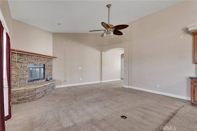 15090 Olema Rd, Apple Valley, CA 92307 - unfurnished living room featuring carpet floors, a ceiling fan, arched walkways, a fireplace, and lofted ceiling