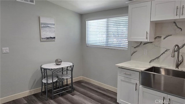 2108 Raleigh Ave, Costa Mesa, CA 92627 - kitchen with dark wood-style floors, backsplash, white cabinets, and light stone countertops
