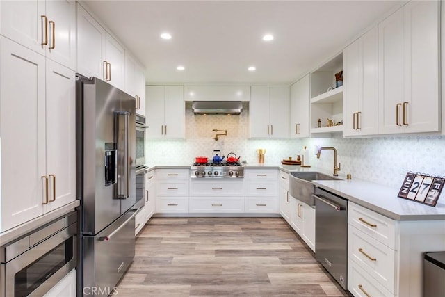 2501 S El Camino Real Unit 310, San Clemente, CA 92672 - kitchen with stainless steel appliances, open shelves, wall chimney range hood, light countertops, and white cabinets
