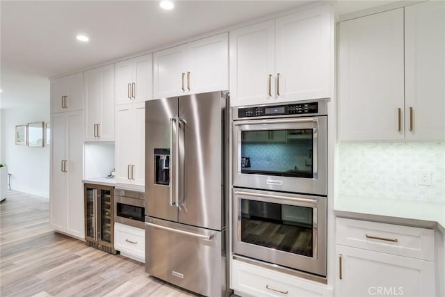 2501 S El Camino Real Unit 310, San Clemente, CA 92672 - kitchen with appliances with stainless steel finishes, beverage cooler, light wood-style floors, recessed lighting, and white cabinetry