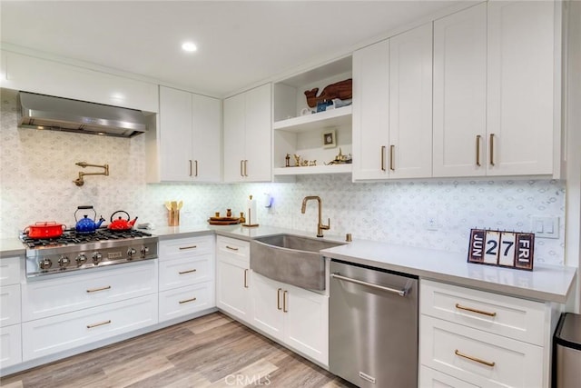 2501 S El Camino Real Unit 310, San Clemente, CA 92672 - kitchen featuring stainless steel appliances, wall chimney range hood, open shelves, light countertops, and white cabinetry