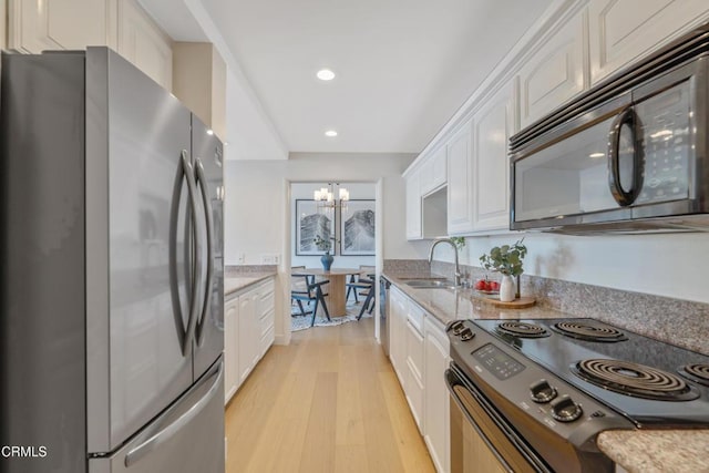 960 San Pasqual St Unit 208, Pasadena, CA 91106 - kitchen featuring black appliances, a chandelier, white cabinets, light wood-type flooring, and recessed lighting