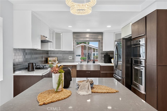 913 Lindencliff St, Torrance, CA 90502 - kitchen with freestanding refrigerator, under cabinet range hood, white cabinetry, modern cabinets, and tasteful backsplash