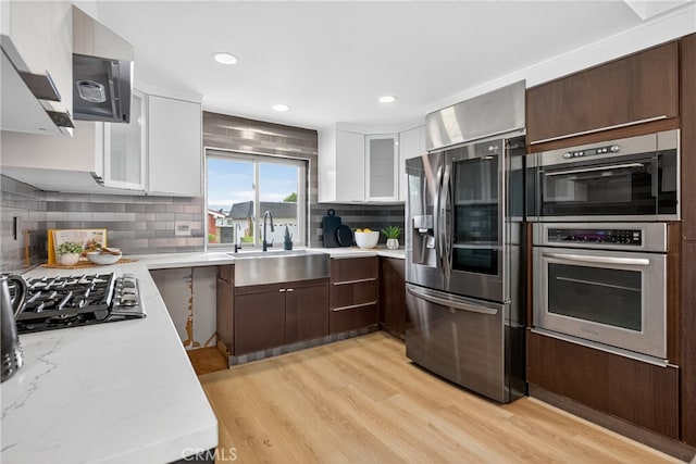 913 Lindencliff St, Torrance, CA 90502 - kitchen with appliances with stainless steel finishes, white cabinets, light wood-type flooring, backsplash, and recessed lighting