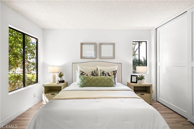 45 Briarglen Unit 64, Irvine, CA 92614 - bedroom with multiple windows, light wood-type flooring, and a textured ceiling