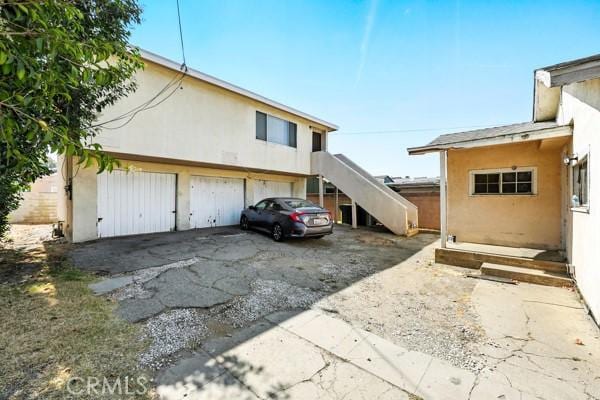 11156 S Grevillea Ave, Hawthorne, CA 90304 - view of property exterior featuring stucco siding, stairs, and driveway