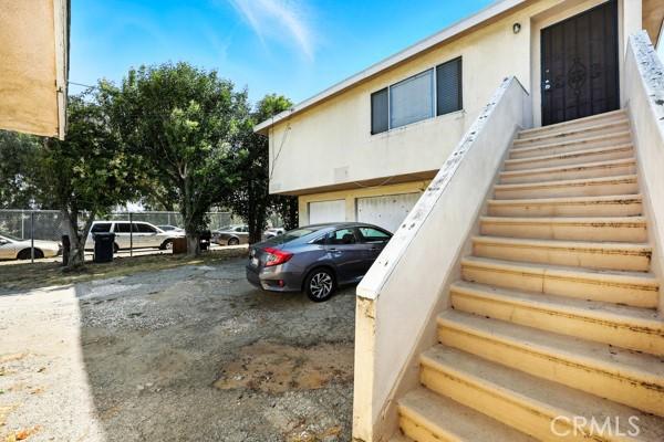 11156 S Grevillea Ave, Hawthorne, CA 90304 - view of home's exterior featuring stairs, an attached garage, and stucco siding