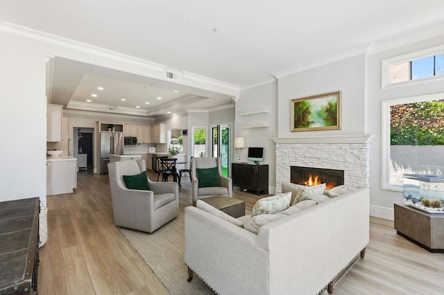 4470 Caminito Tecera, Del Mar, CA 92014 - living room featuring crown molding, light wood-style floors, a stone fireplace, and a raised ceiling