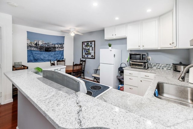 214 Woodland Pkwy Unit 206, San Marcos, CA 92069 - kitchen featuring freestanding refrigerator, stainless steel microwave, a ceiling fan, white cabinetry, and dark wood-style flooring