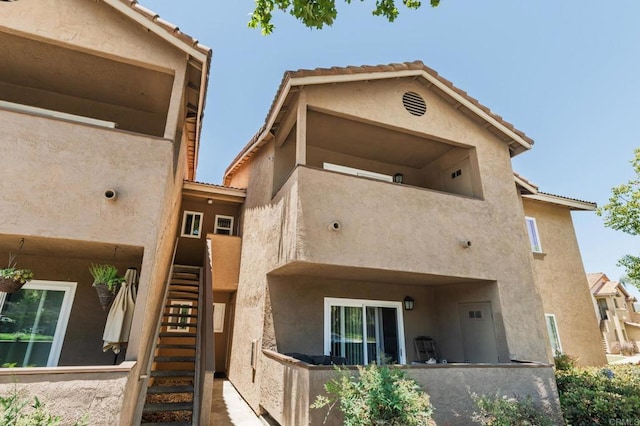 214 Woodland Pkwy Unit 206, San Marcos, CA 92069 - back of property with stairs, stucco siding, and a tiled roof