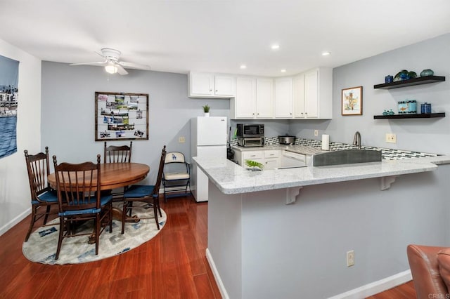 214 Woodland Pkwy Unit 206, San Marcos, CA 92069 - kitchen with a peninsula, stainless steel microwave, light stone countertops, dark wood finished floors, and recessed lighting