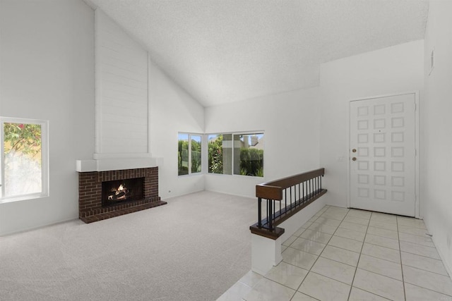 13443 Black Hills Rd, San Diego, CA 92129 - tiled entryway featuring healthy amount of natural light, high vaulted ceiling, a brick fireplace, a textured ceiling, and carpet