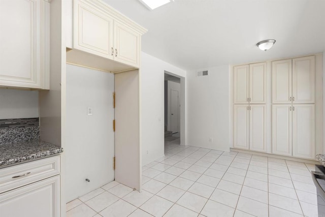 13443 Black Hills Rd, San Diego, CA 92129 - kitchen with cream cabinetry, dark stone countertops, and light tile patterned flooring
