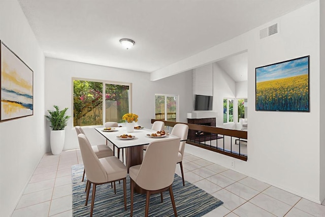 13443 Black Hills Rd, San Diego, CA 92129 - dining room featuring light tile patterned floors, a fireplace, and vaulted ceiling