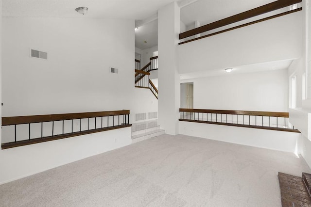 13443 Black Hills Rd, San Diego, CA 92129 - unfurnished living room with carpet floors, a towering ceiling, and stairway