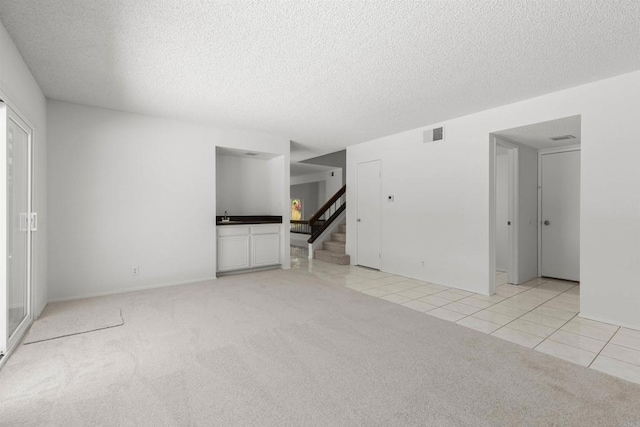 13443 Black Hills Rd, San Diego, CA 92129 - unfurnished living room featuring light colored carpet, stairs, light tile patterned floors, and a textured ceiling