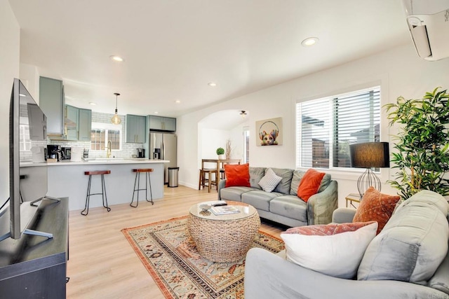 376378 Acacia Dr, Carlsbad, CA 92008 - living room featuring arched walkways, light wood-style flooring, recessed lighting, and a wall mounted air conditioner