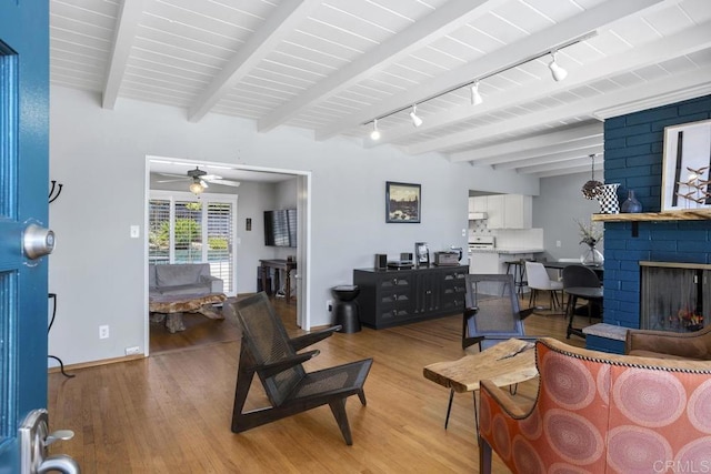 1001 Ontario St, Escondido, CA 92025 - living area featuring light wood-style floors, beam ceiling, a ceiling fan, rail lighting, and a brick fireplace