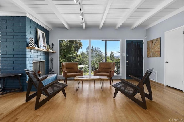 1001 Ontario St, Escondido, CA 92025 - living area with track lighting, light wood-type flooring, beamed ceiling, and a brick fireplace