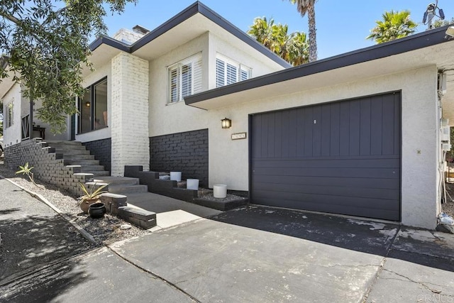 1001 Ontario St, Escondido, CA 92025 - view of front of house featuring stucco siding, a garage, driveway, and brick siding