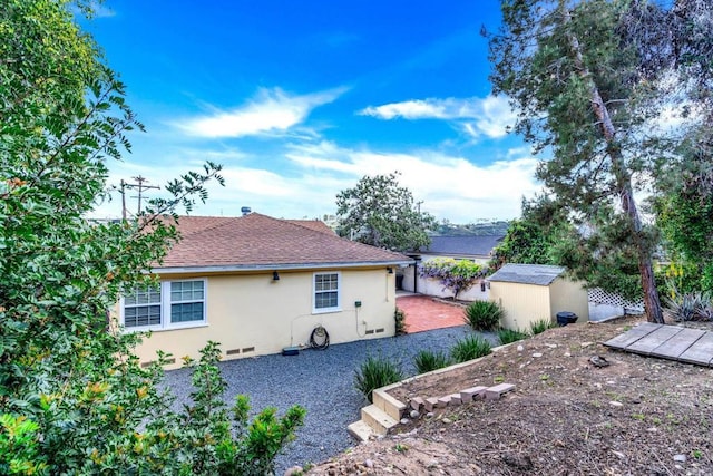 4920 Elsa Rd, San Diego, CA 92120 - view of side of property with stucco siding, a storage shed, and a shingled roof