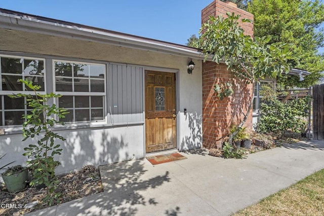 929 Diamond St, Monrovia, CA 91016 - view of exterior entry featuring a chimney, a patio, stucco siding, and brick siding