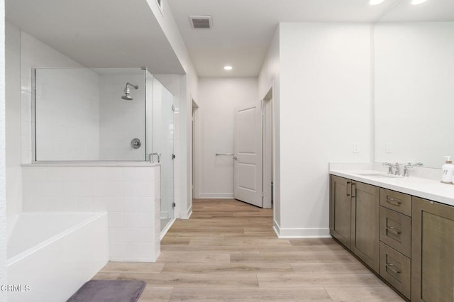 2850 Wagon Wheel Rd Unit 402, Oxnard, CA 93036 - bathroom with a stall shower, a bath, vanity, wood finished floors, and recessed lighting