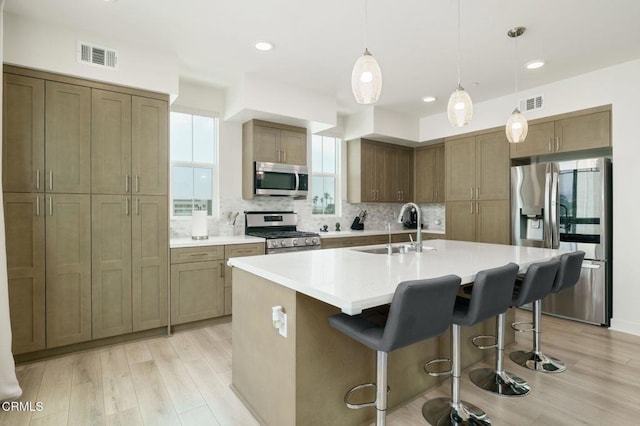2850 Wagon Wheel Rd Unit 402, Oxnard, CA 93036 - kitchen with stainless steel appliances, light wood finished floors, backsplash, a breakfast bar, and recessed lighting